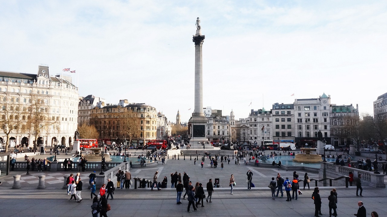 Praça Trafalgar Square com fontes e leões de bronze ao redor da coluna